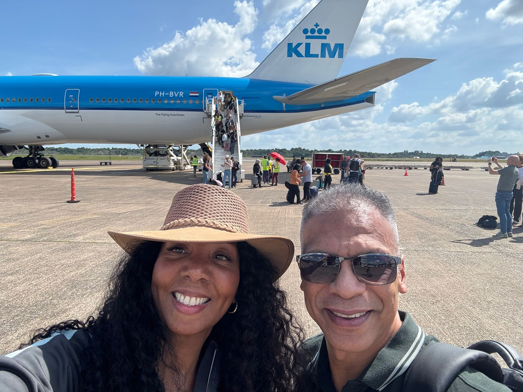 Health Tribe couple arriving for a trip beside an airplane