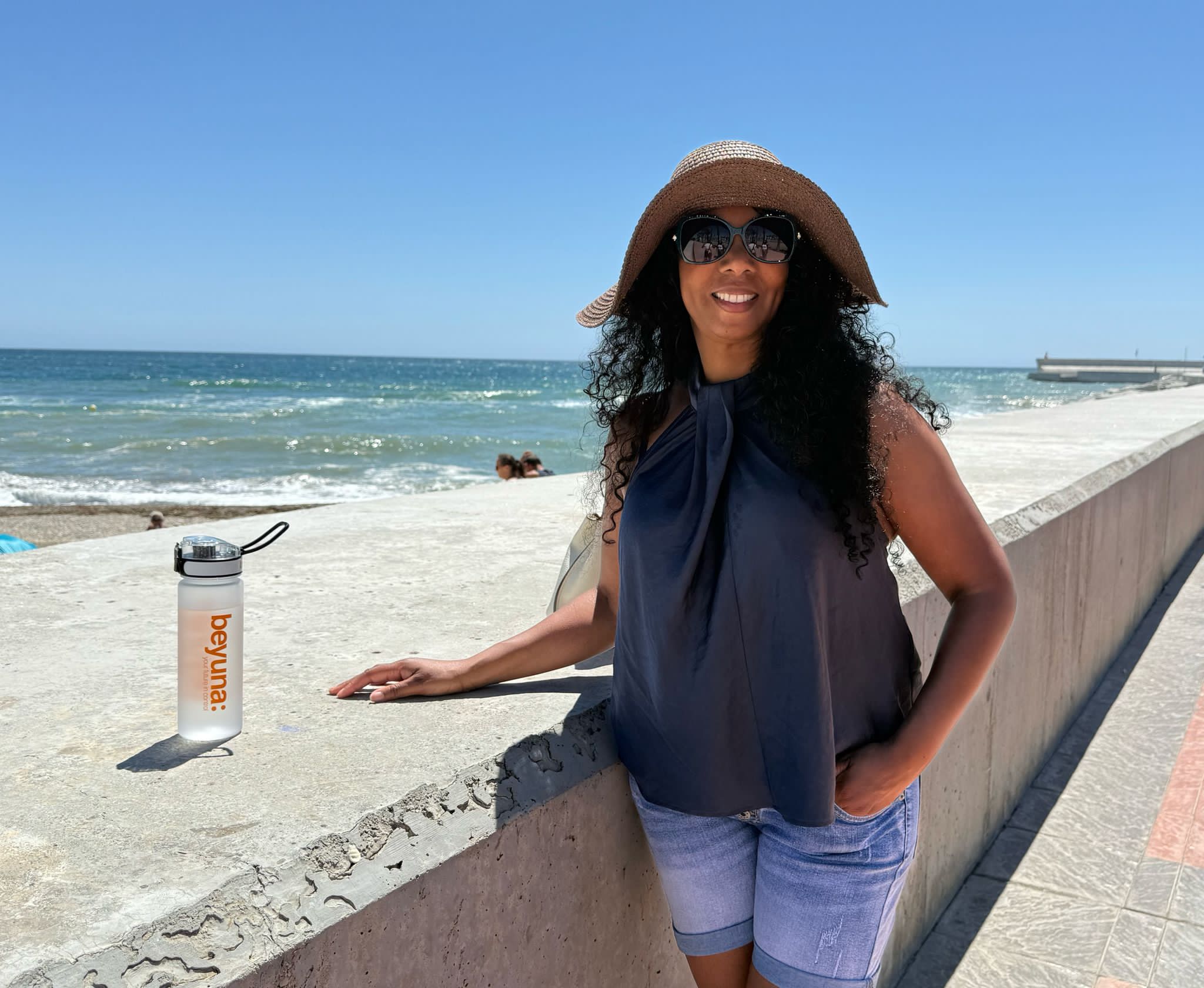 Health Tribe woman beside the sea with a Beyuna water bottle